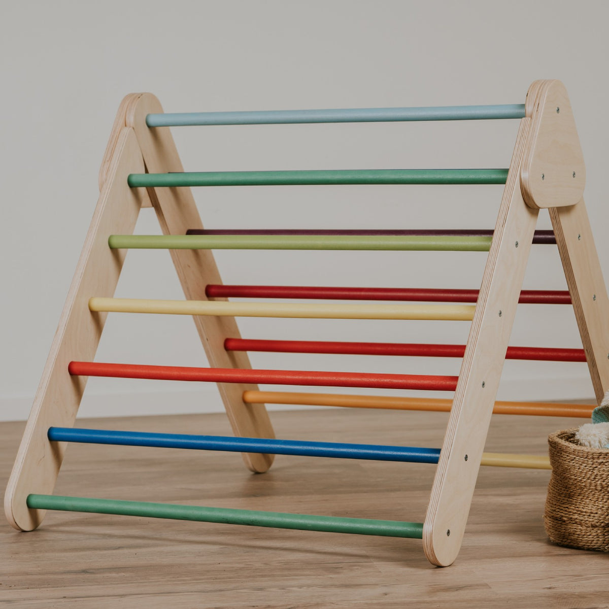 Triángulo Pikler de madera con barras de colores arcoíris